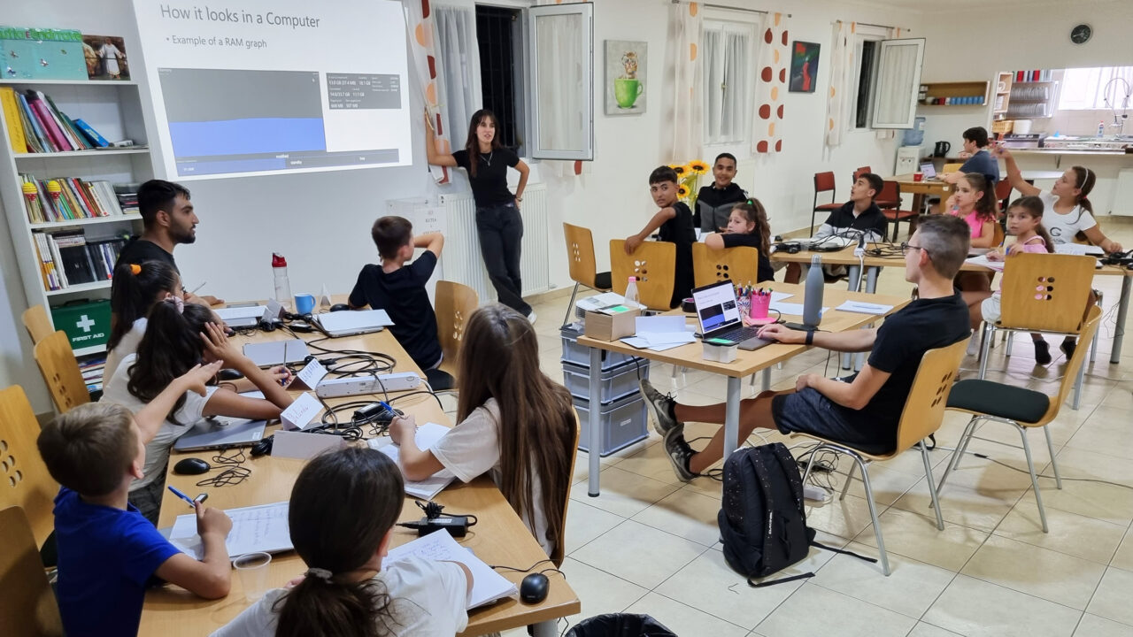 Eine Frau hält eine Power-Point-Präsentation vor etwa 15 Jugendlichen