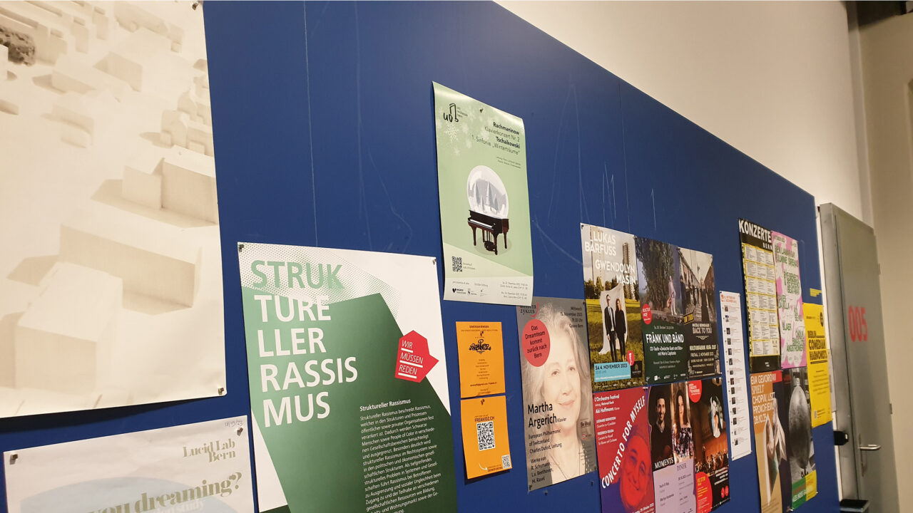 Plakatwand in einem Uni-Gebäude im vonRoll Bern