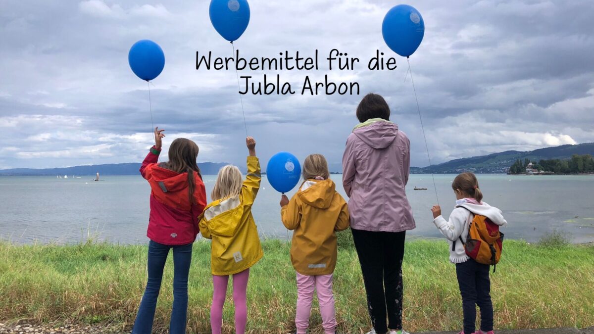 Kinder mit Luftballons vor einem See