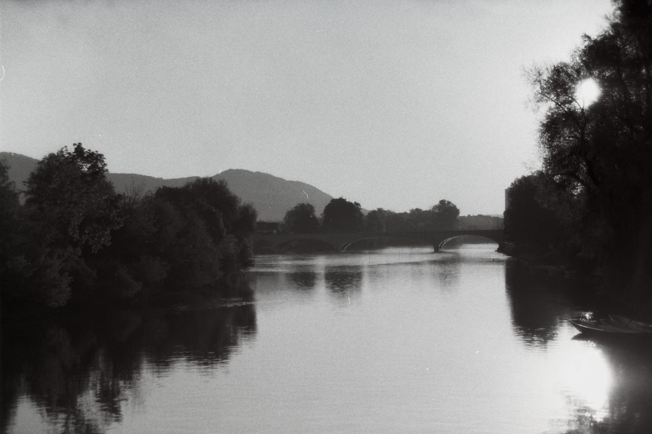Schwarzweissfotografie des Flusses Aare mit der Kettenbrücke in Aarau.
