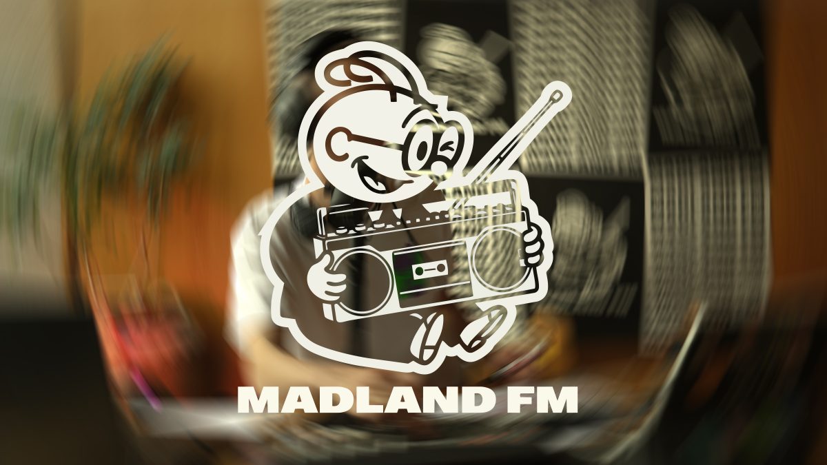 MADLAND FM Key-Visual mit verschwommenem Radiostudio im Hintergrund.